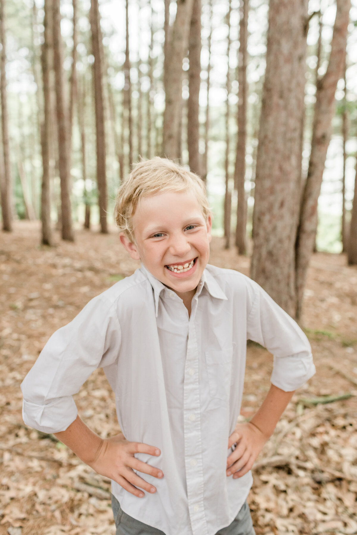 little boy laughing in the woods