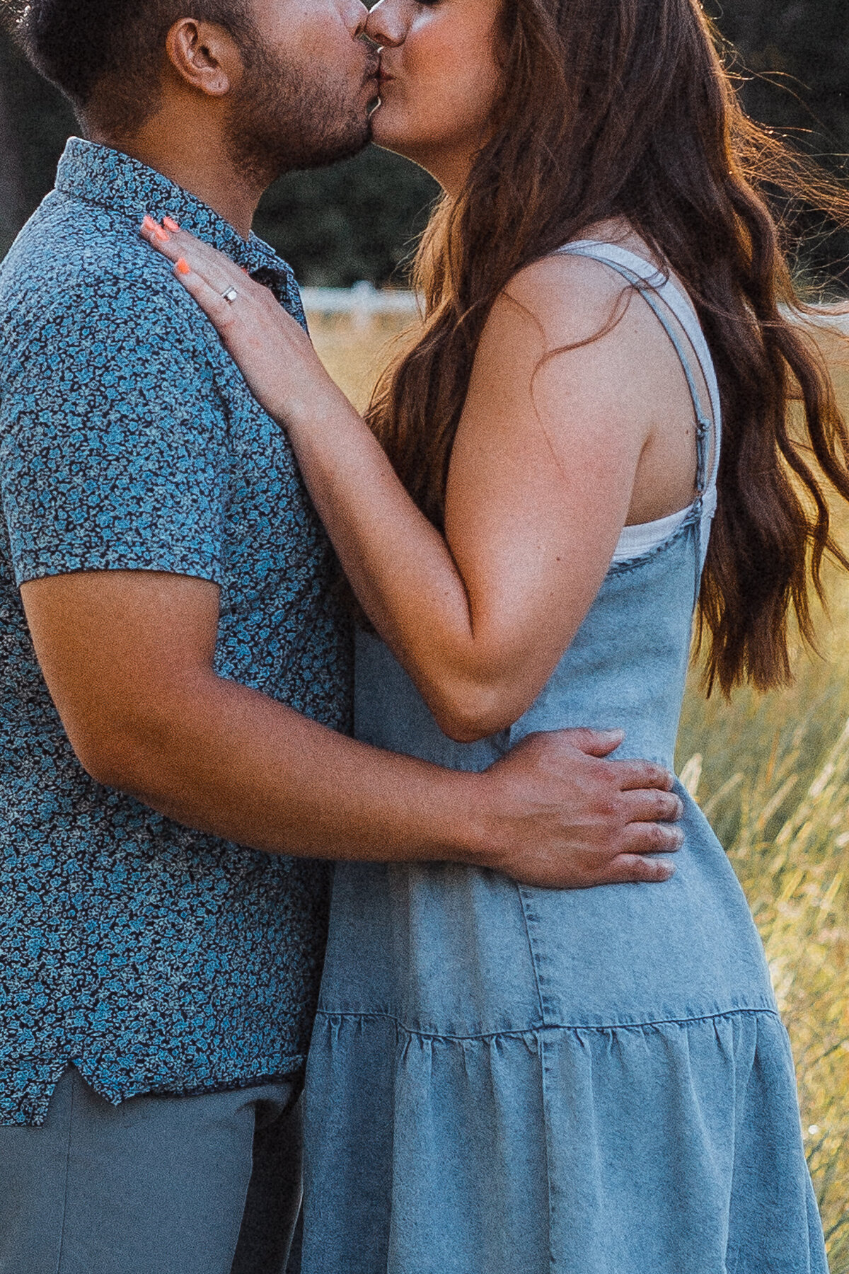 Husband and wife in a field at sunset, in natural light.