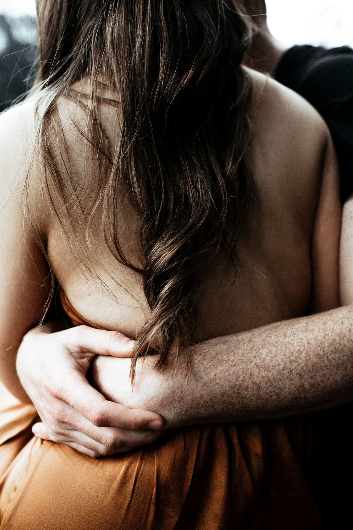 Details photo of hair and pretty rust dress. Man hugging woman. Candid Couples Photography in Melbourne. Redwood Forest Engagement Photography Session. Sapphire and Stone Photography