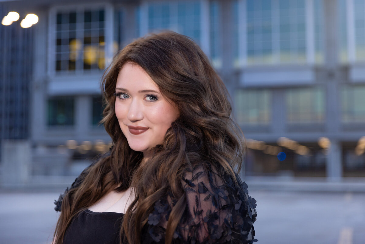 Beautiful Raleigh Building with lights behind this high school senior.