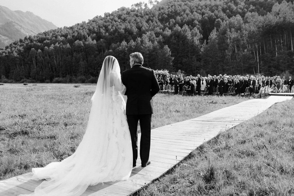 Bride walking down the aisle at an outdoor wedding venue near Aspen Colorado