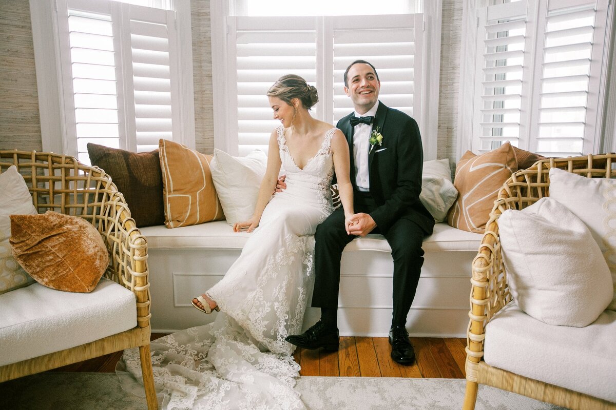 Bride and groom sitting on window seat together