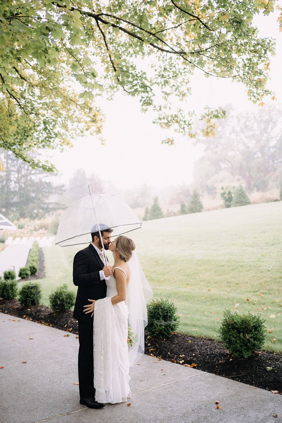 Bride and groom kissing holding an umbrella at Finger Lakes Wedding, NY