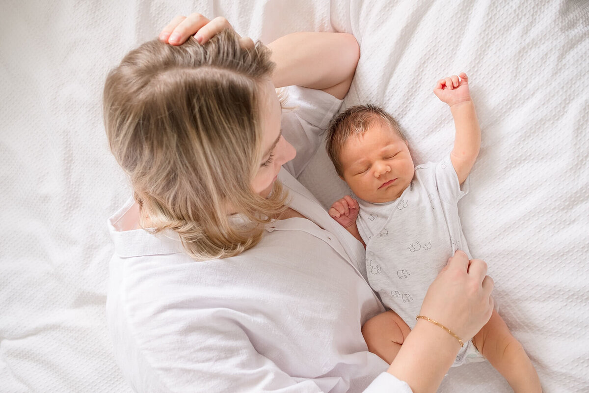 mum holding baby in white nurses by Hikari Lifestyle Photography, a Gold Coast maternity photographer