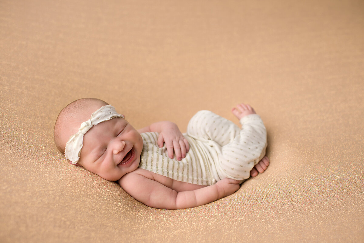 indoors shot of newborn laying on a all tan backdrop
