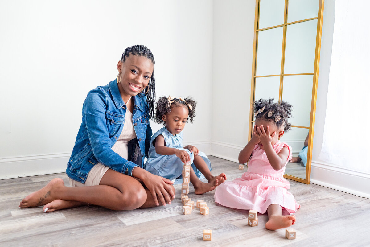 A mom and her two daughters play in the floor during family pictures in HUntsville Alabama