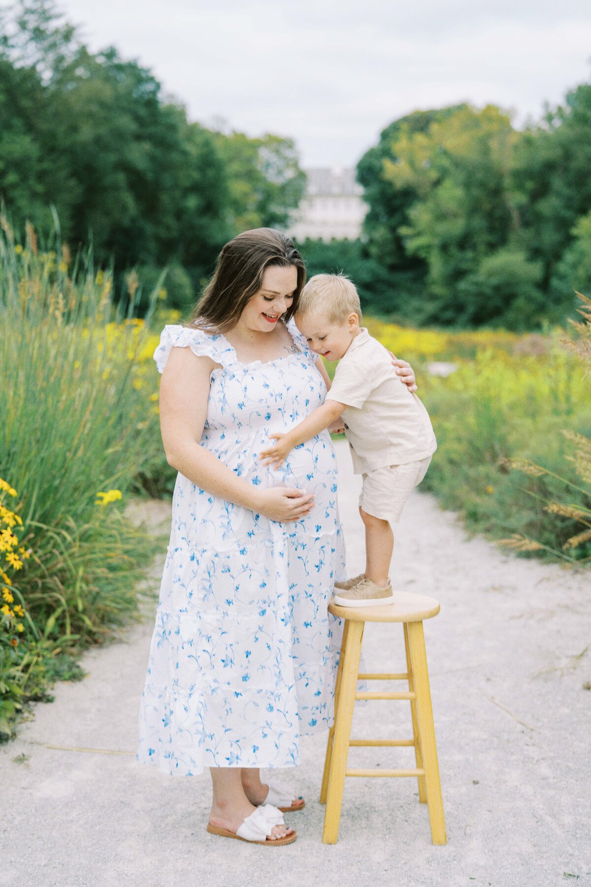 pregnant mom touching belly with toddler son