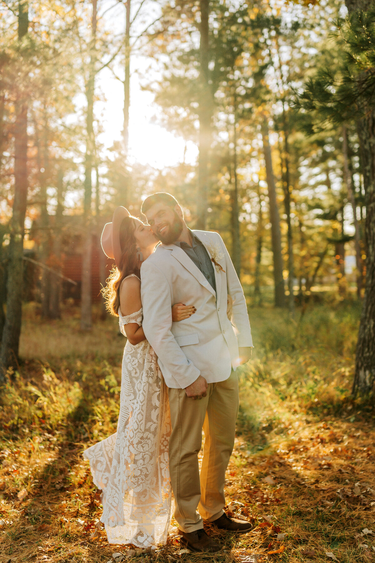 wife kissing husband's cheek at sunset