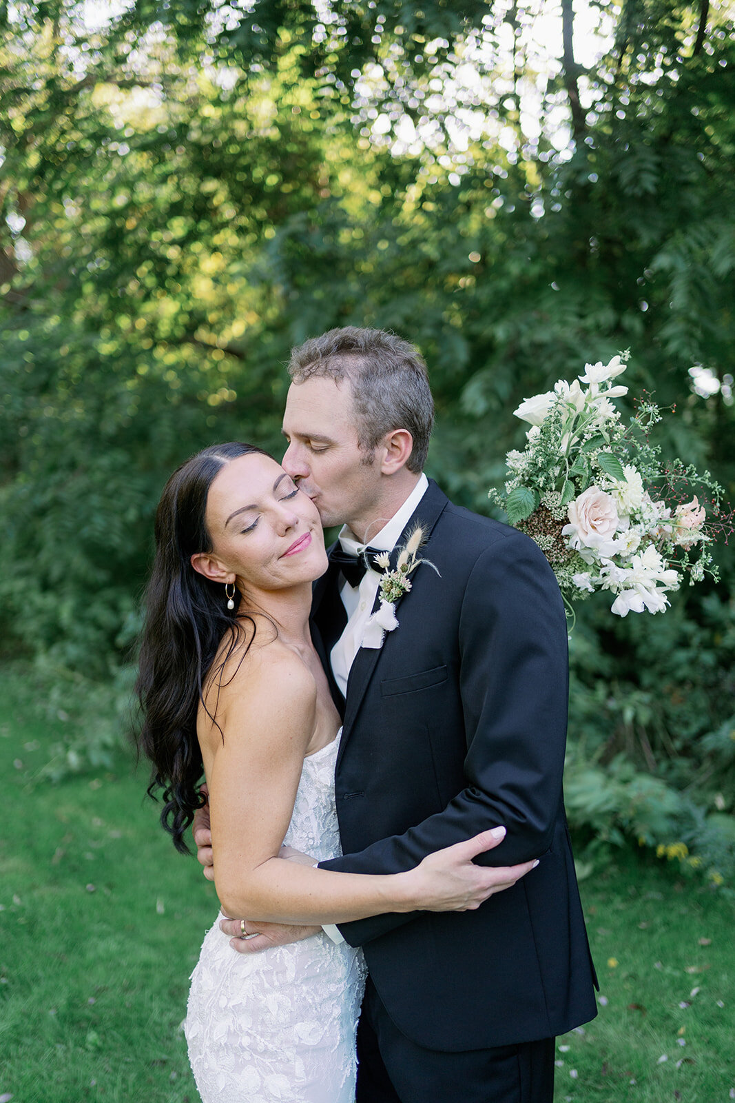 Bride and groom smiling at each other in golden hour sun at Glasshouse Community during their summer Michigan wedding.