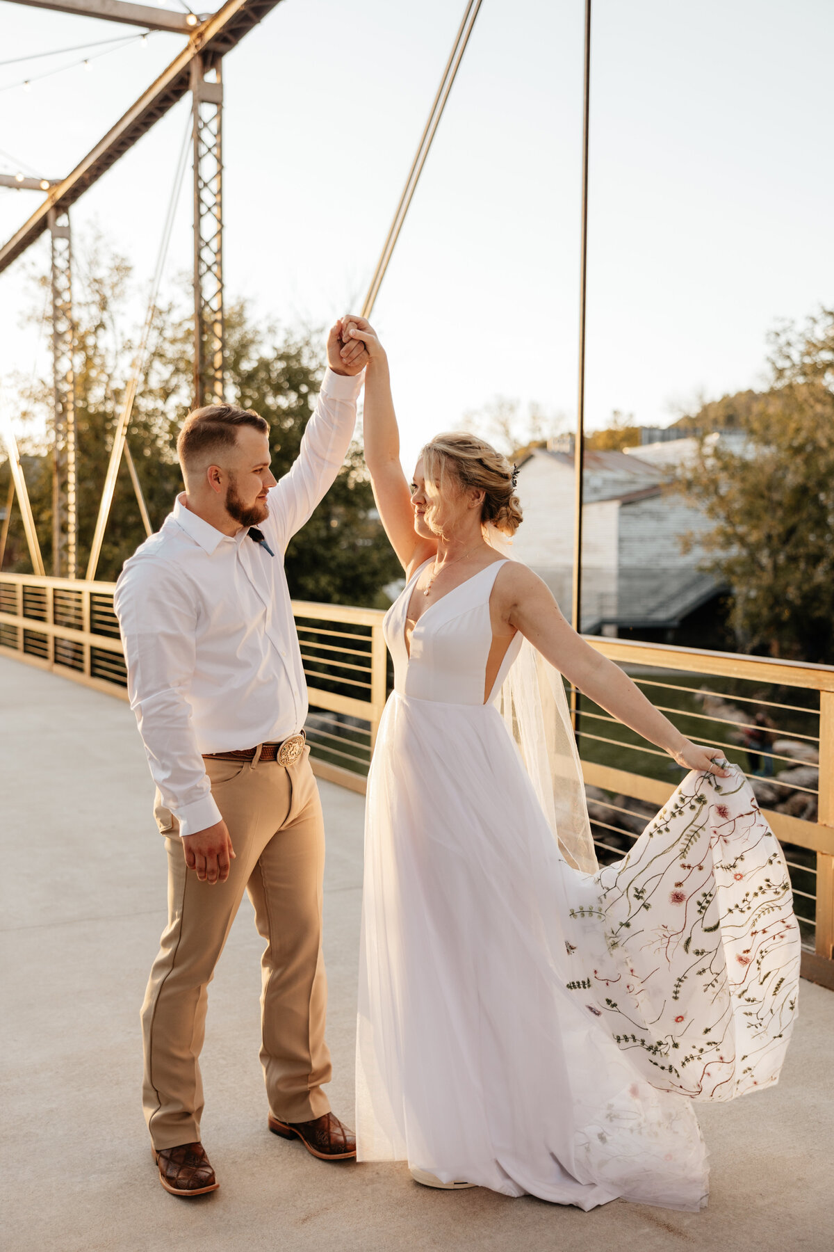 bride twirling on a bridge