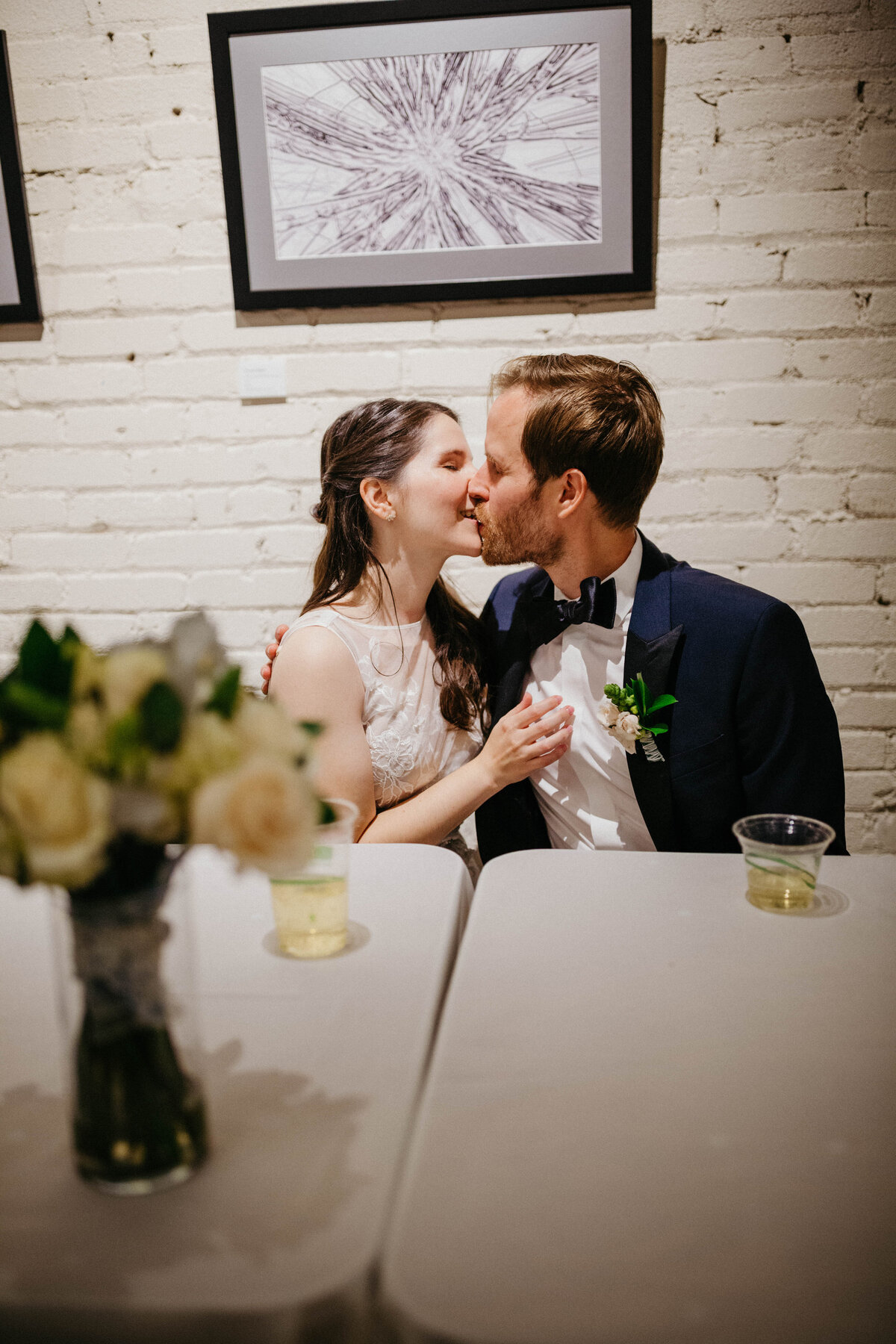 couple-kissing-at-head-table