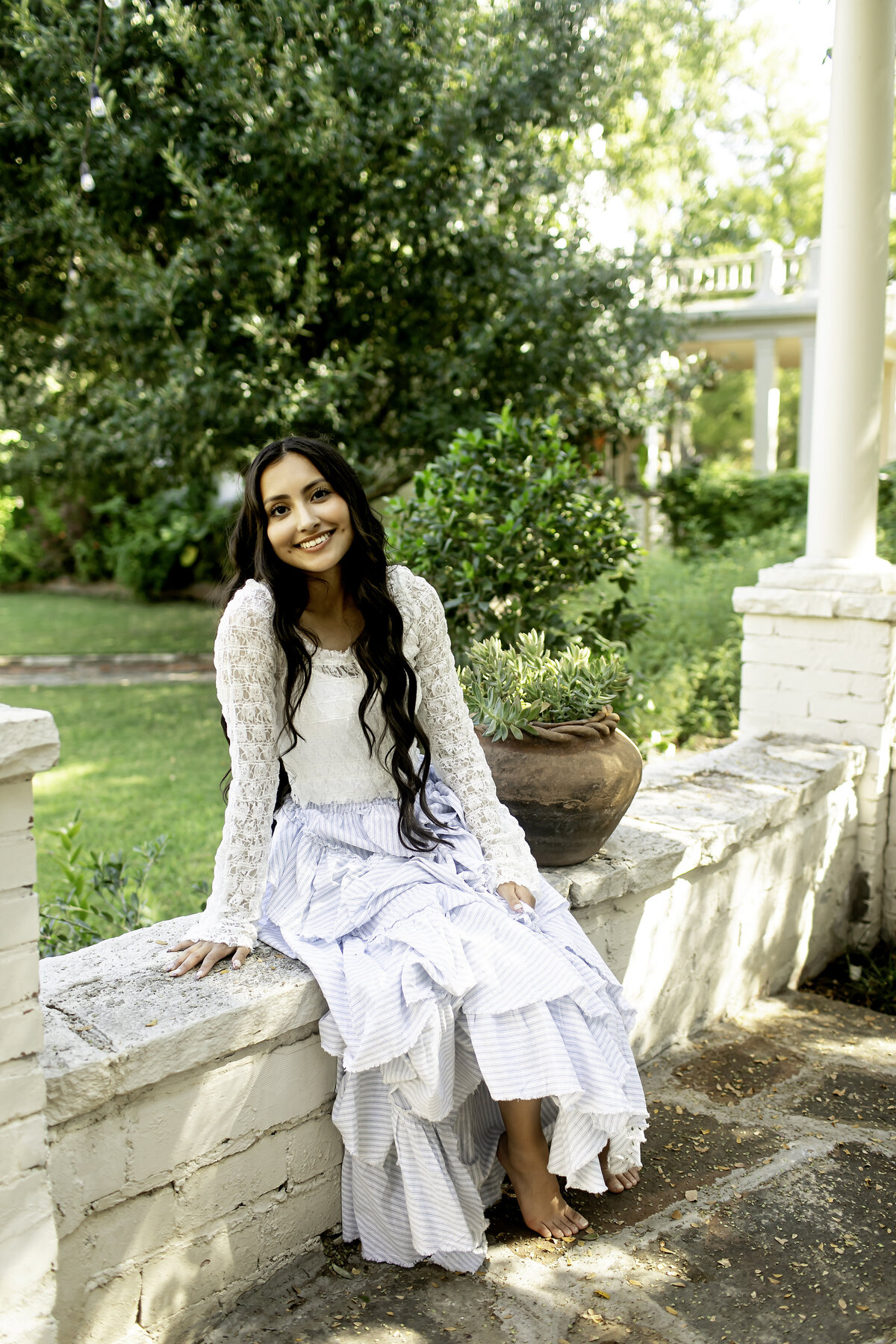A high school senior joyfully posing amidst the colorful blooms of Chandor Gardens, with the tranquil setting symbolizing both her accomplishments and bright future