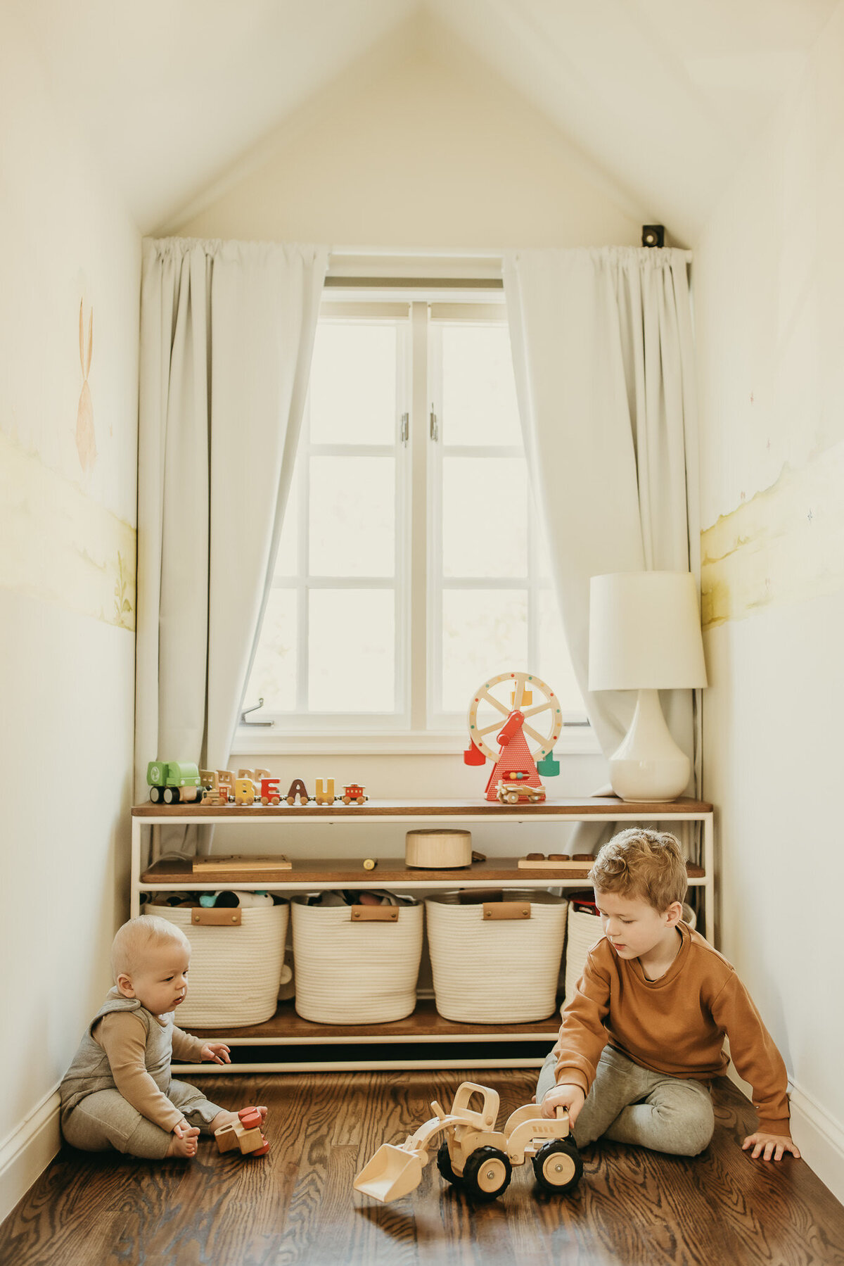 Bay area brothers play with toy truck in front of bedroom window during in home family photography session