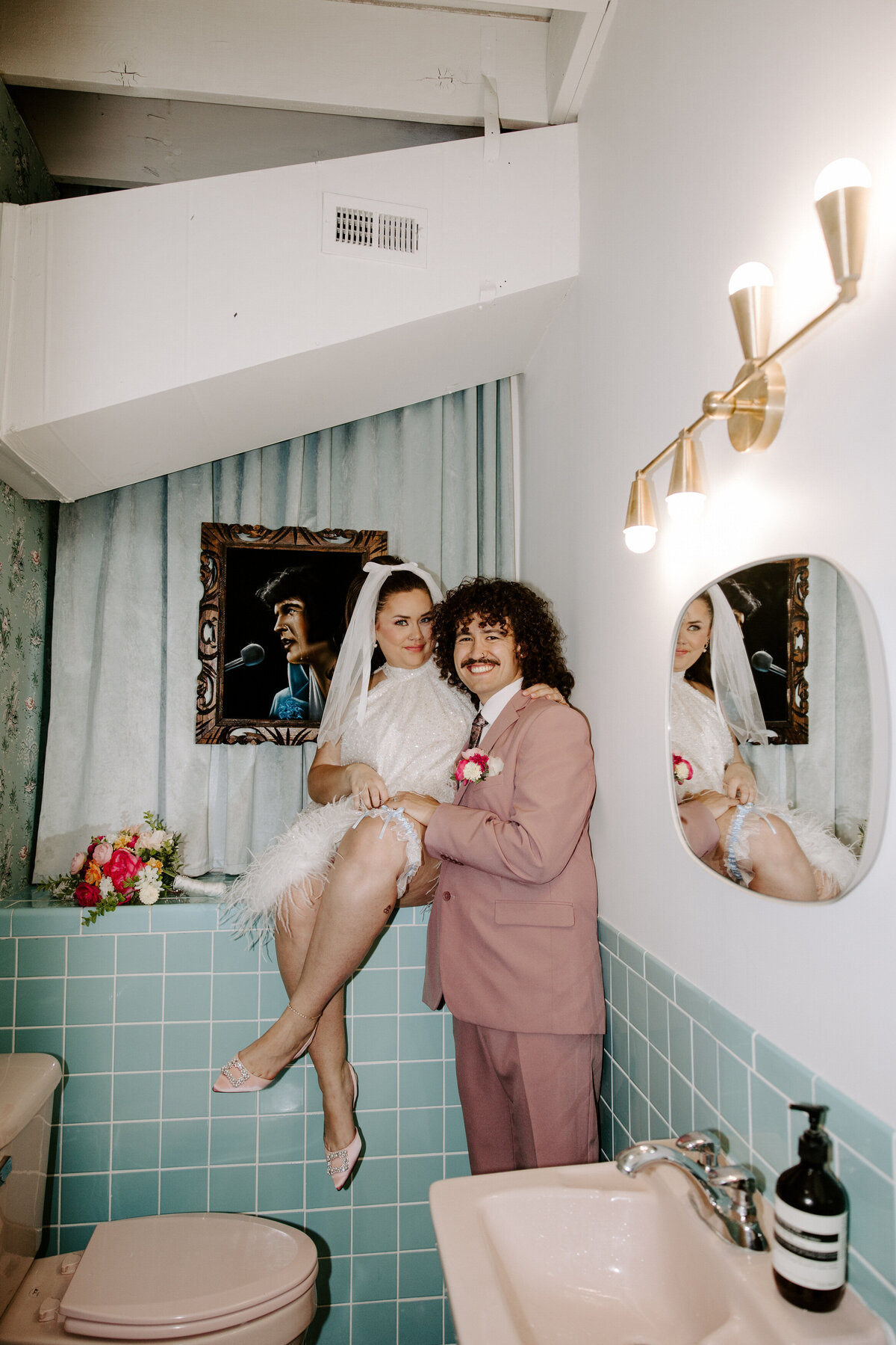 A couple poses in a bathroom on their elopement day in Vegas.