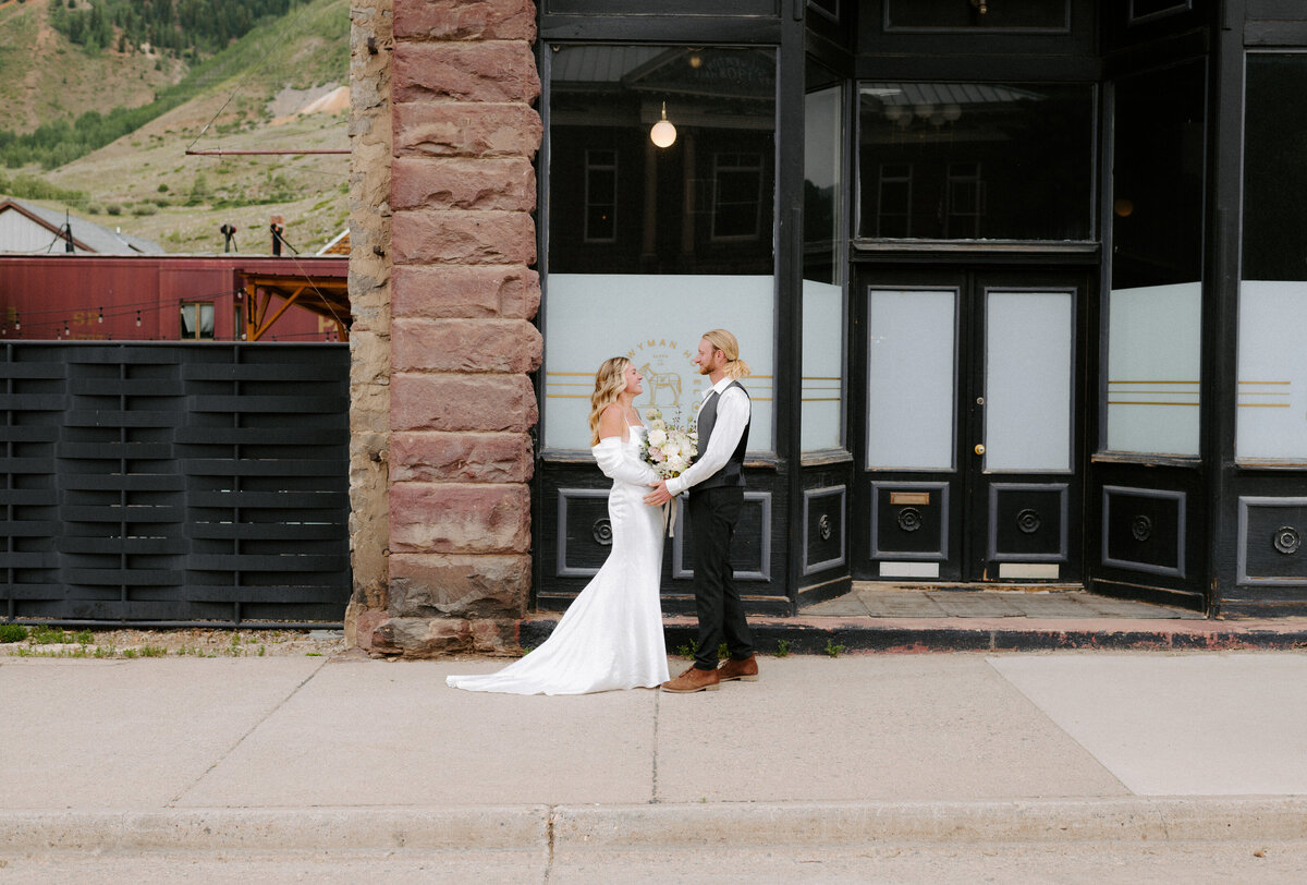 Bride and groom stand outside of the Wyman hotel in Silverton Colorado