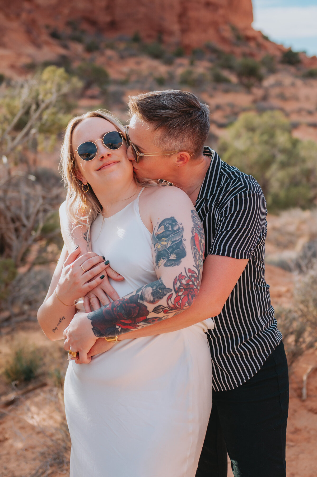 A couple kisses and hugs outdoors