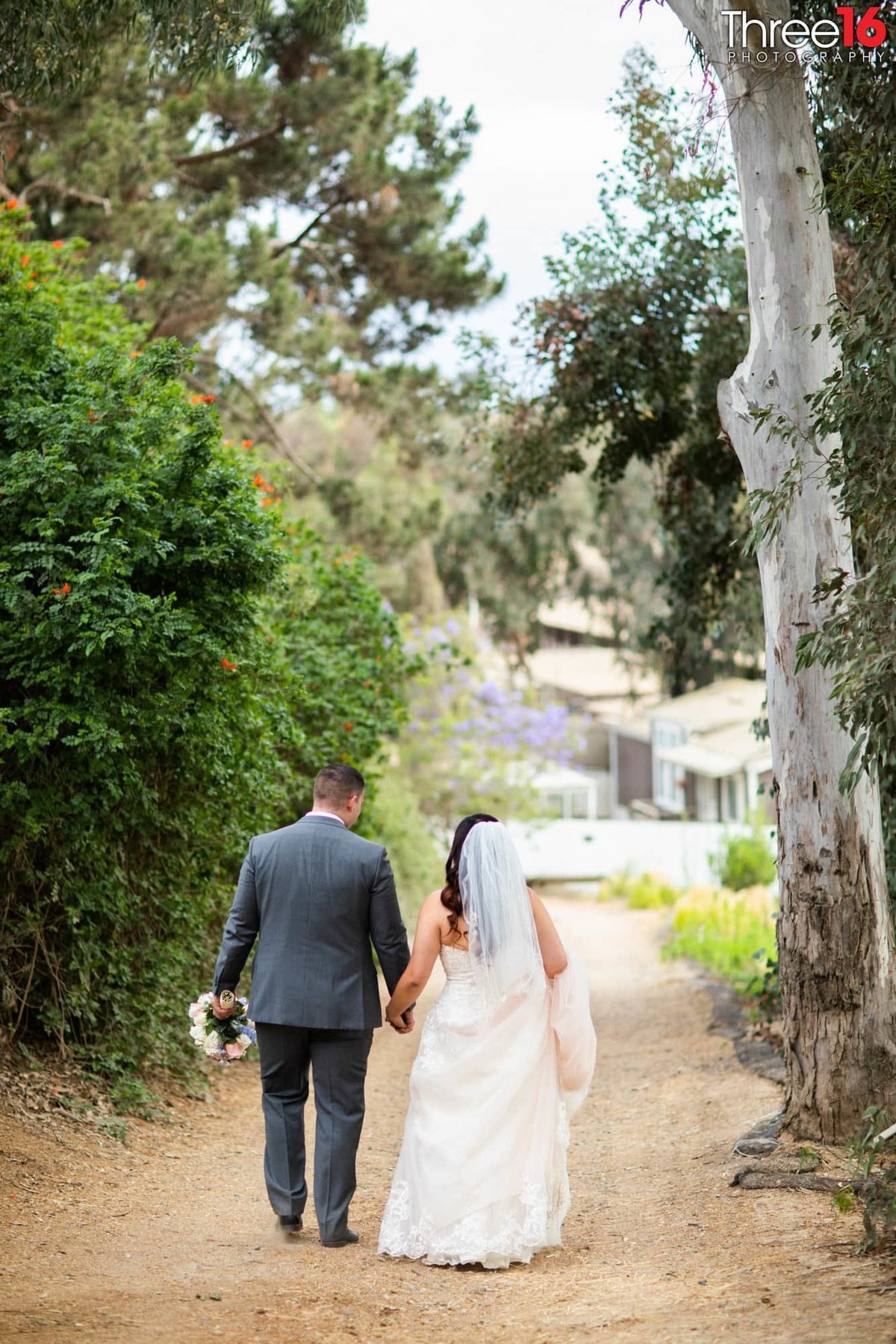 Bride and Groom walk away  holding hands