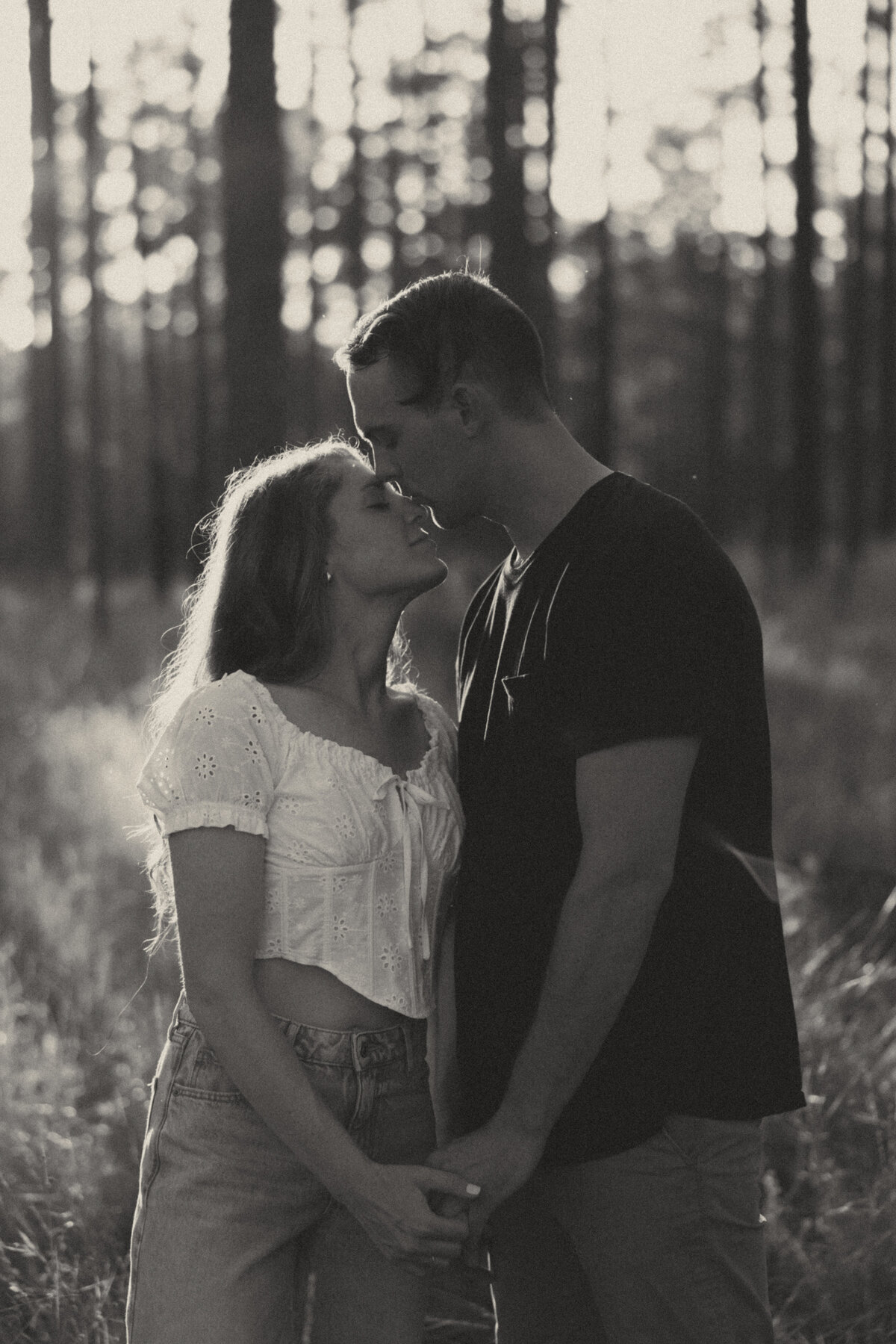 Couple posing for portraits in a forest.