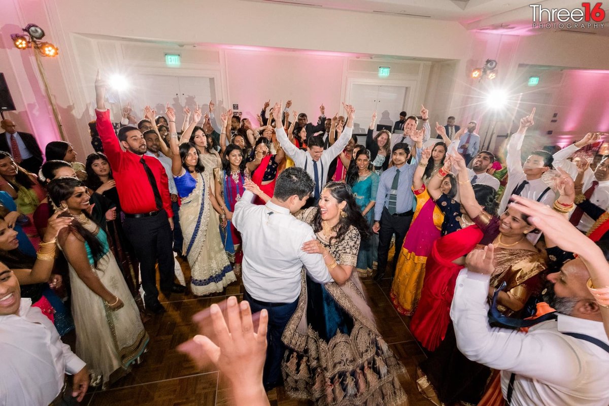 Guests cheer the newly married couple's first dance