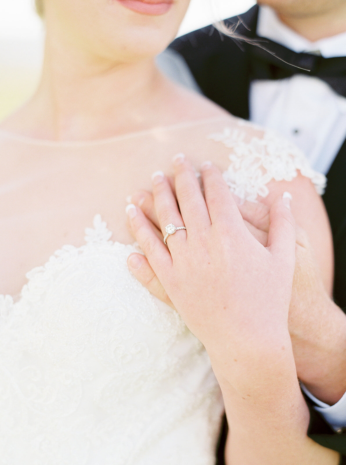 close up of bride and groom touching hands