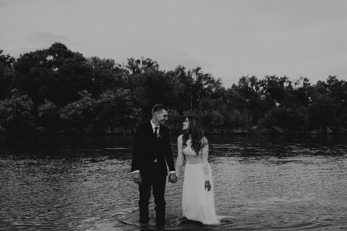 bride and groom walking through New Mexico river