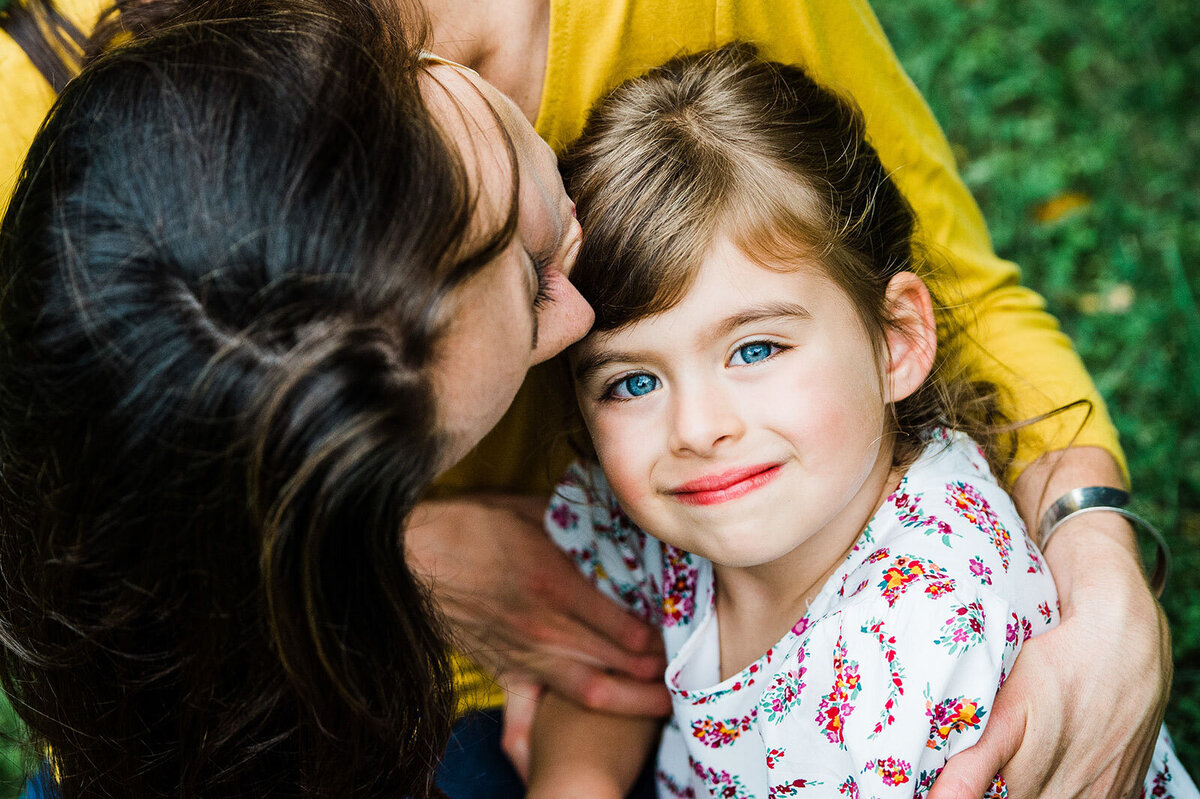 mother kissing toddler daughter in vermont