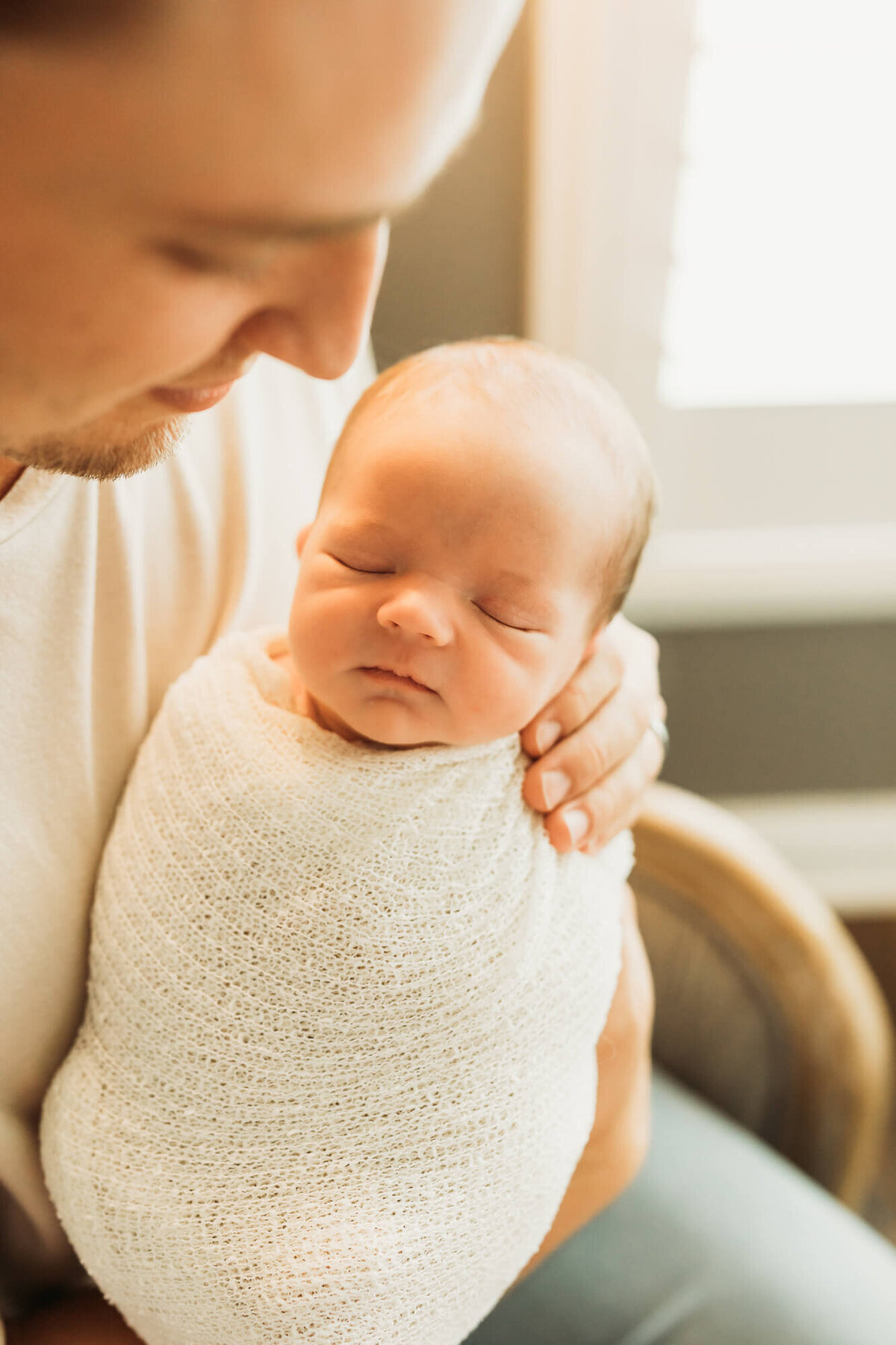 Dad glancing at his new baby boy during in home newborn session in Houston, Texas.