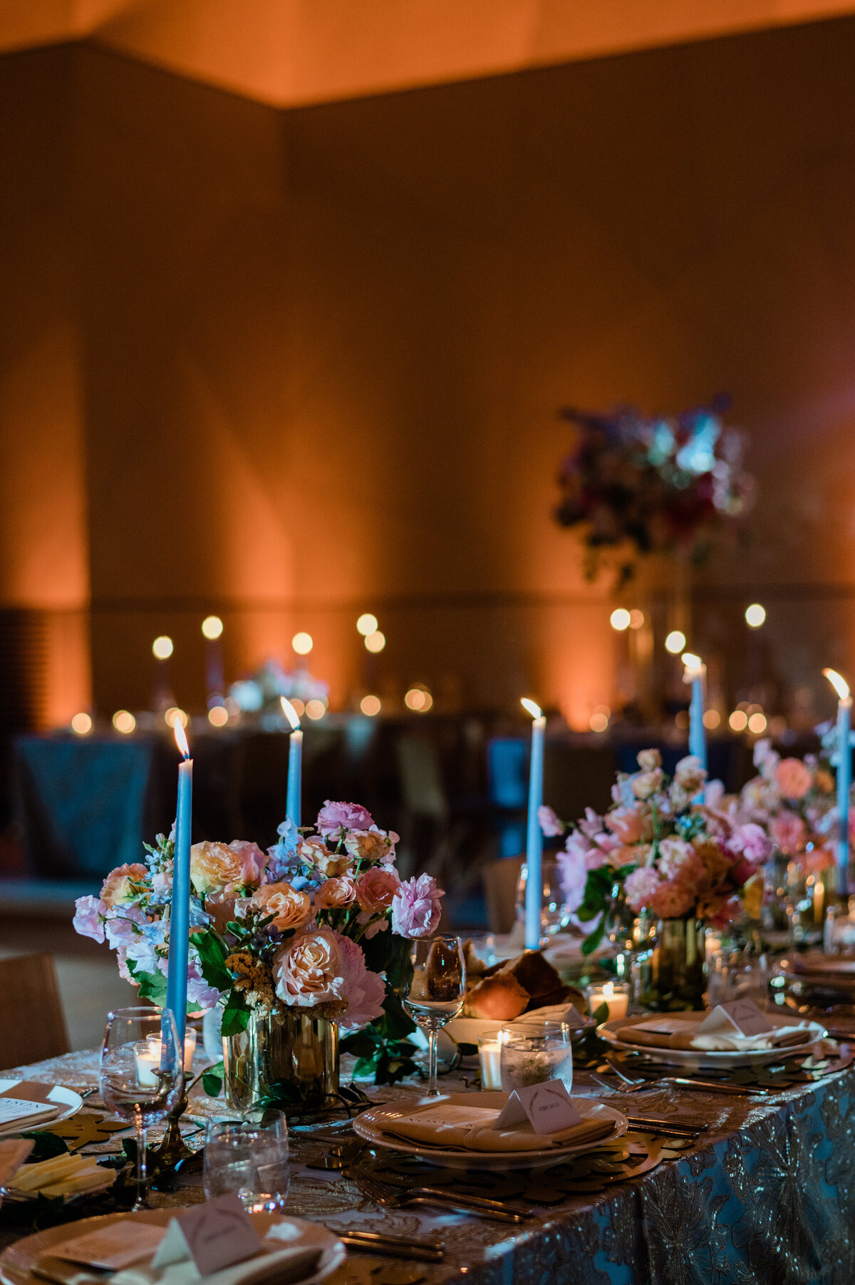 Candle lit center pieces surrounded by florals 