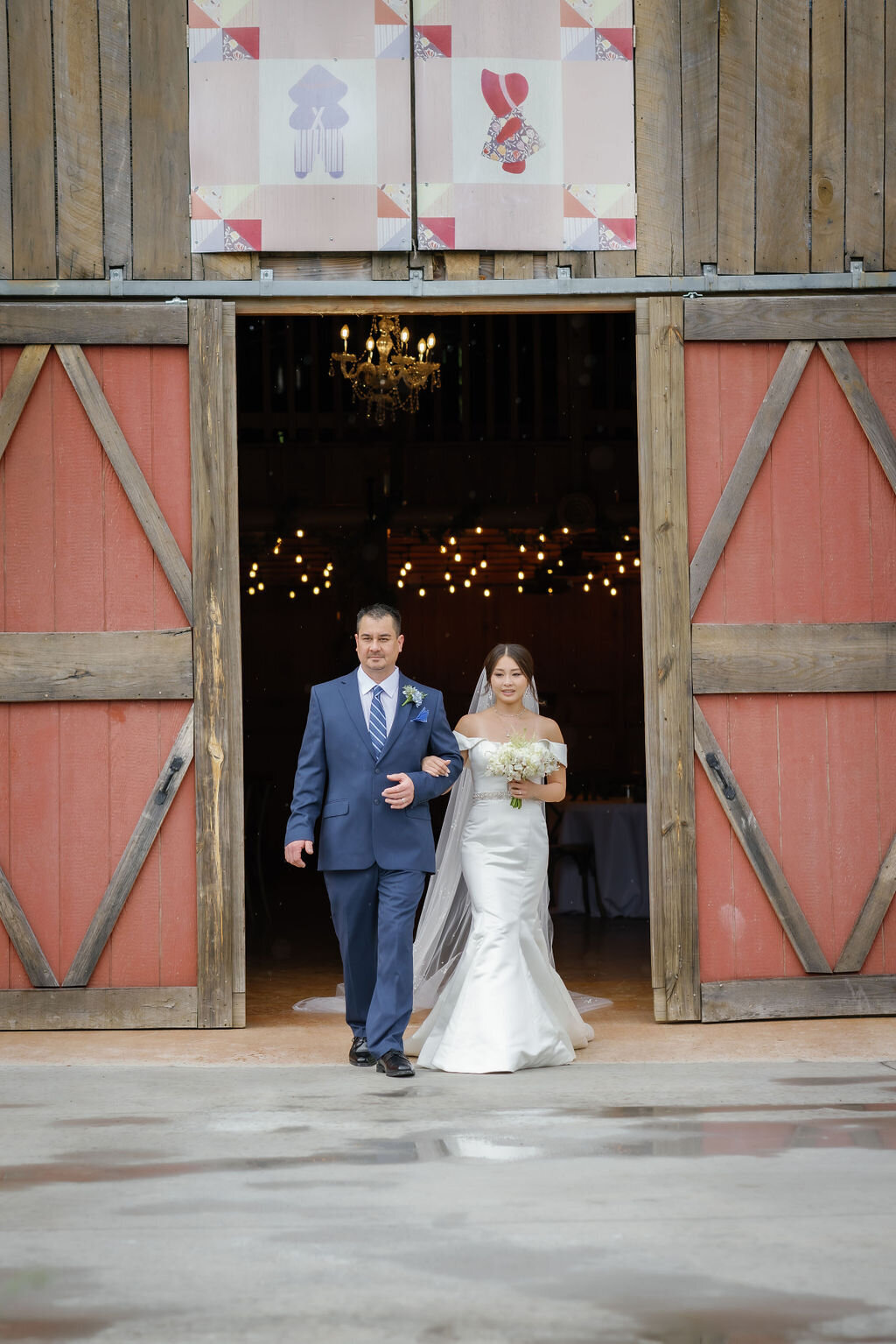 father of the bride walks his daughter out of a red barn at Mountain Mist Farms up the aisle for her Smoky Mountain elopement ceremony captured by wedding photographers gatlinburg tn 