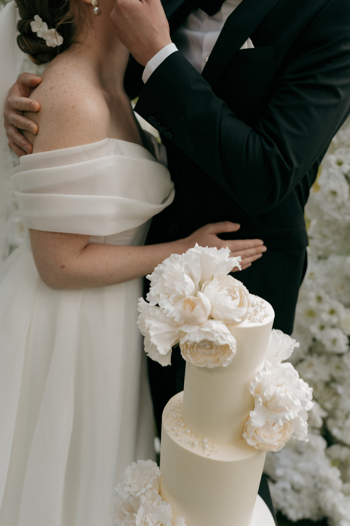 Foto van bruidstaart met bloemen.