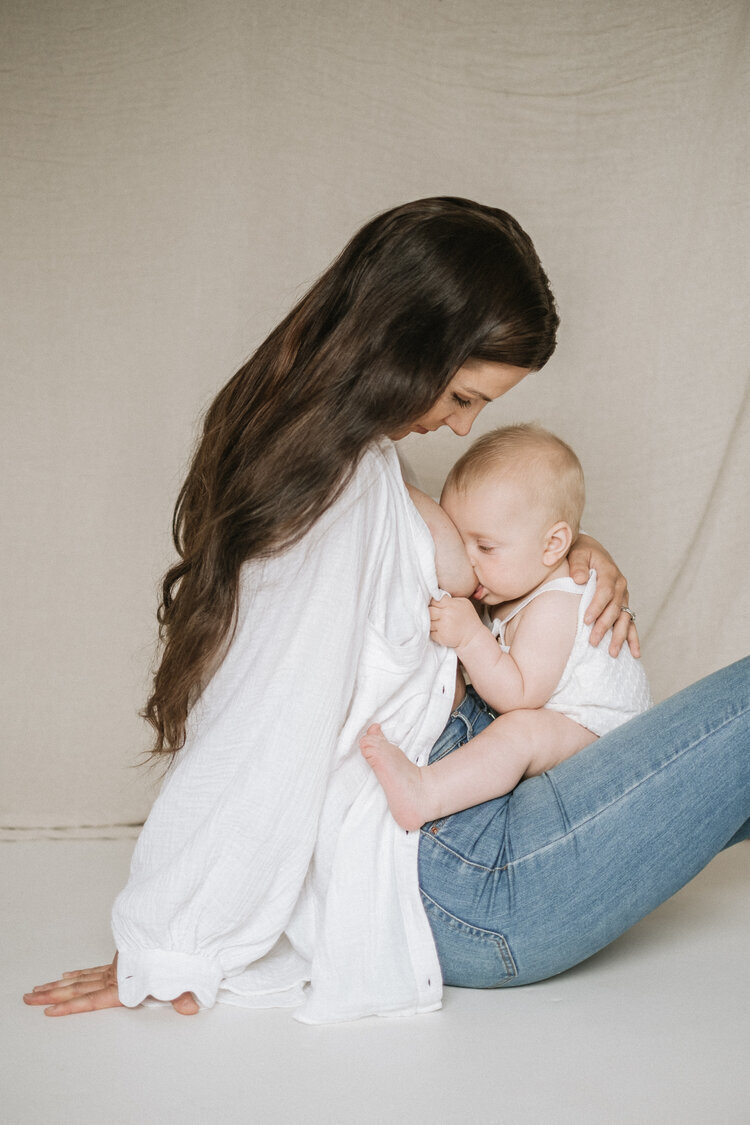 Mother in jeans breastfeeds her baby