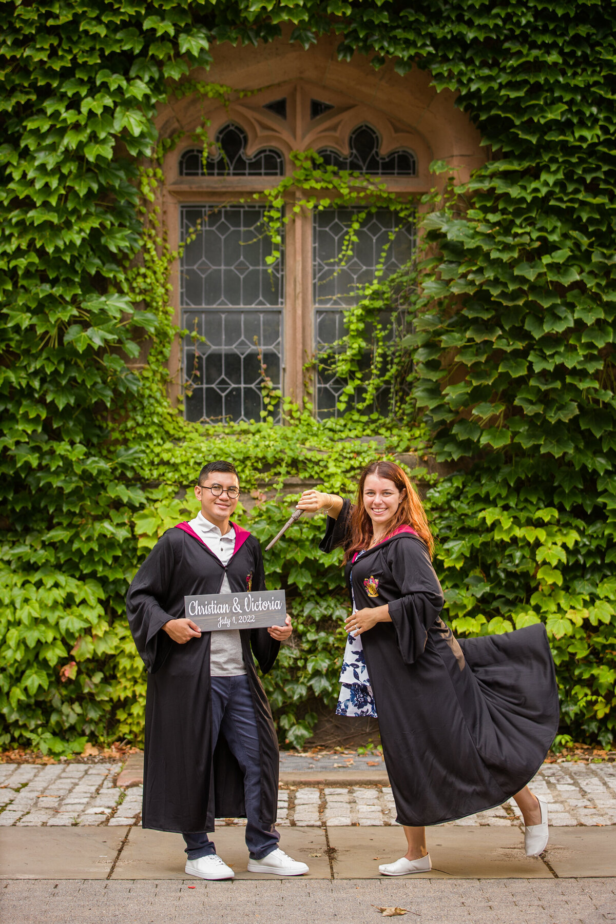 An engaged couple striking a magical Harry Potter-inspired pose during their engagement session at Princeton University, blending literary charm with the iconic and historic beauty of the campus setting.