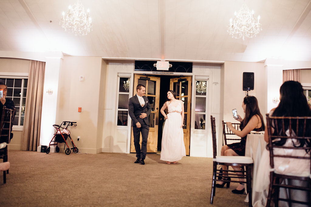 Wedding Photograph Of Groomsman And Bridesmaid Staring At Each Other While Entering The Reception Hall Los Angeles