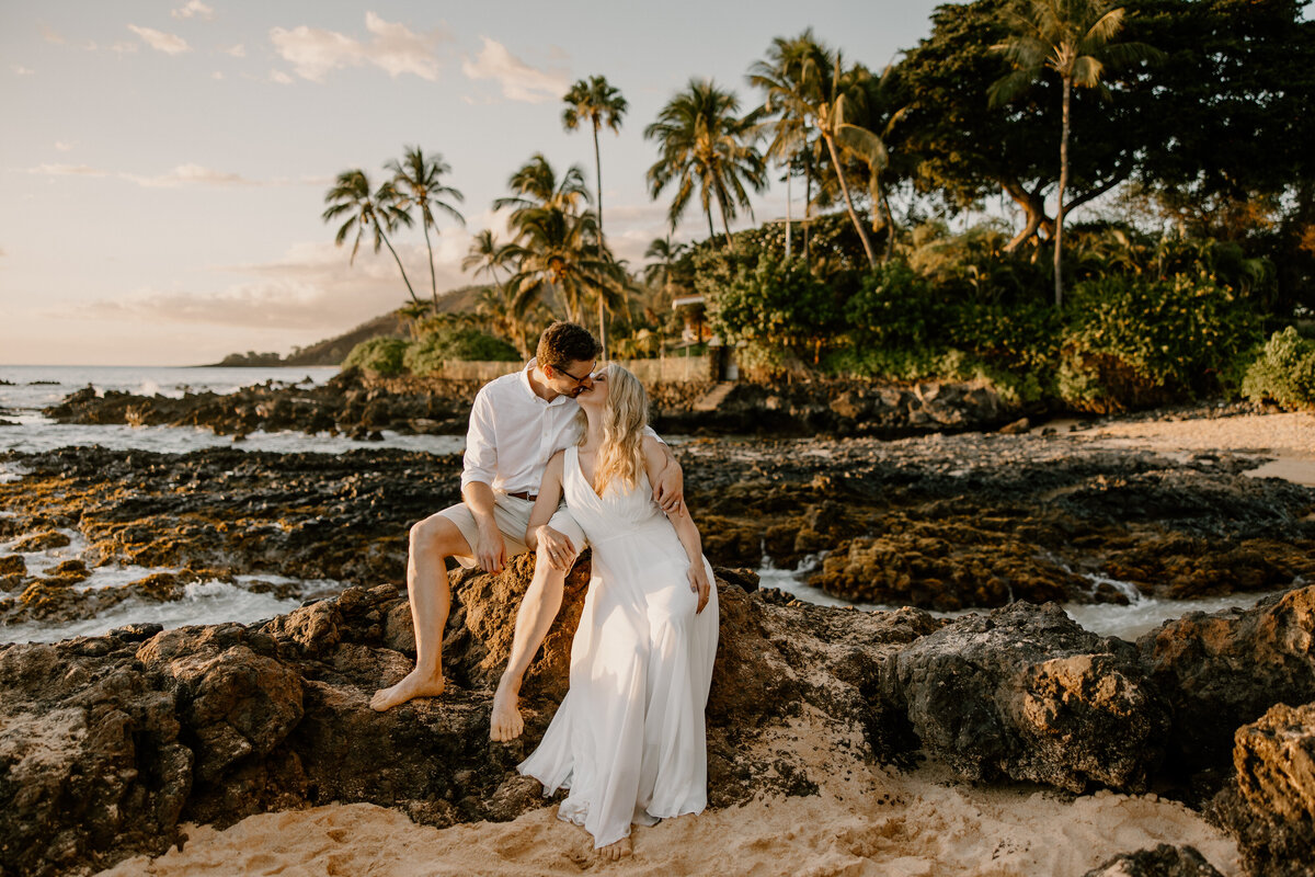 Maui Wedding Photographer captures bride and groom sitting on rocks on beach