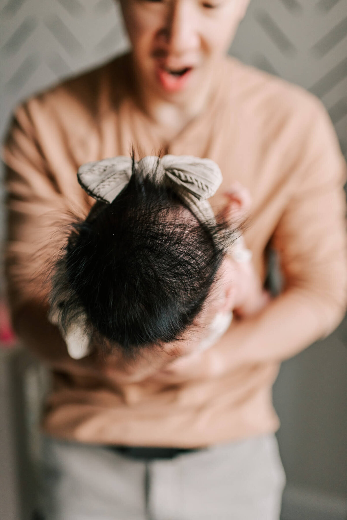 a closeup shot of a newborn girl's hair while dad holds her