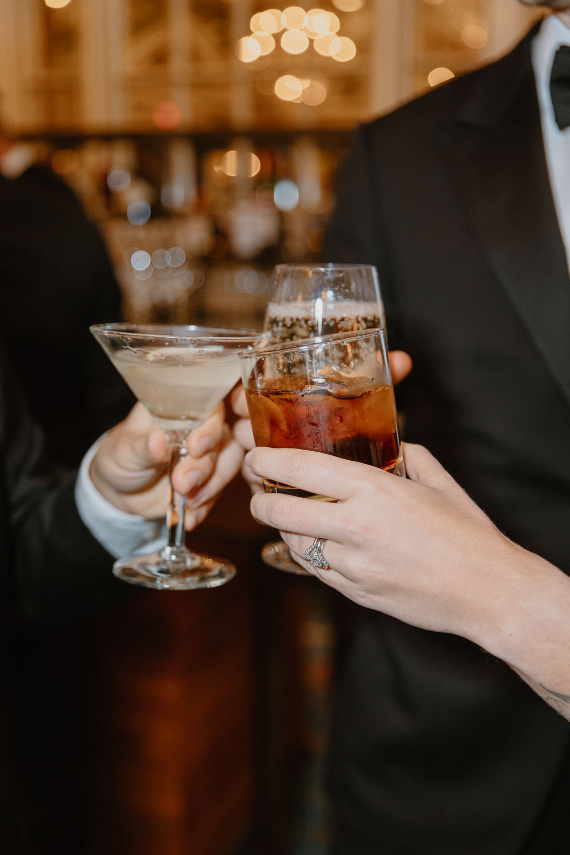 A close-up photo of wedding guests cheersing and clinking glasses during cocktail hour | Boston Fairmont Copley Plaza Hotel Wedding