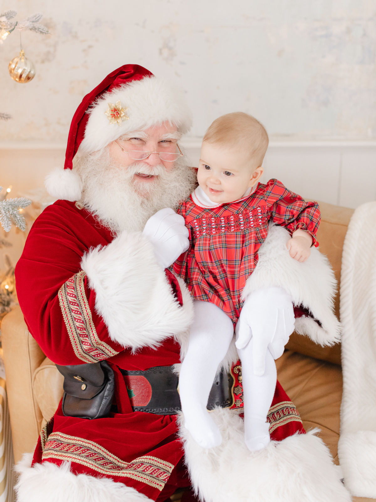 santa holds baby girl and they both smile for photo
