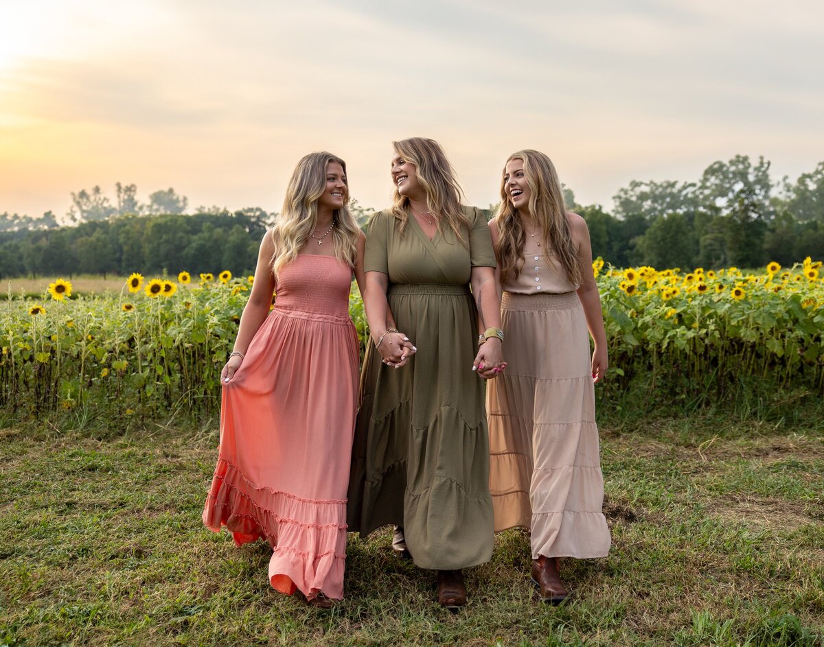 a group of women in dresses in a field of sunflowers