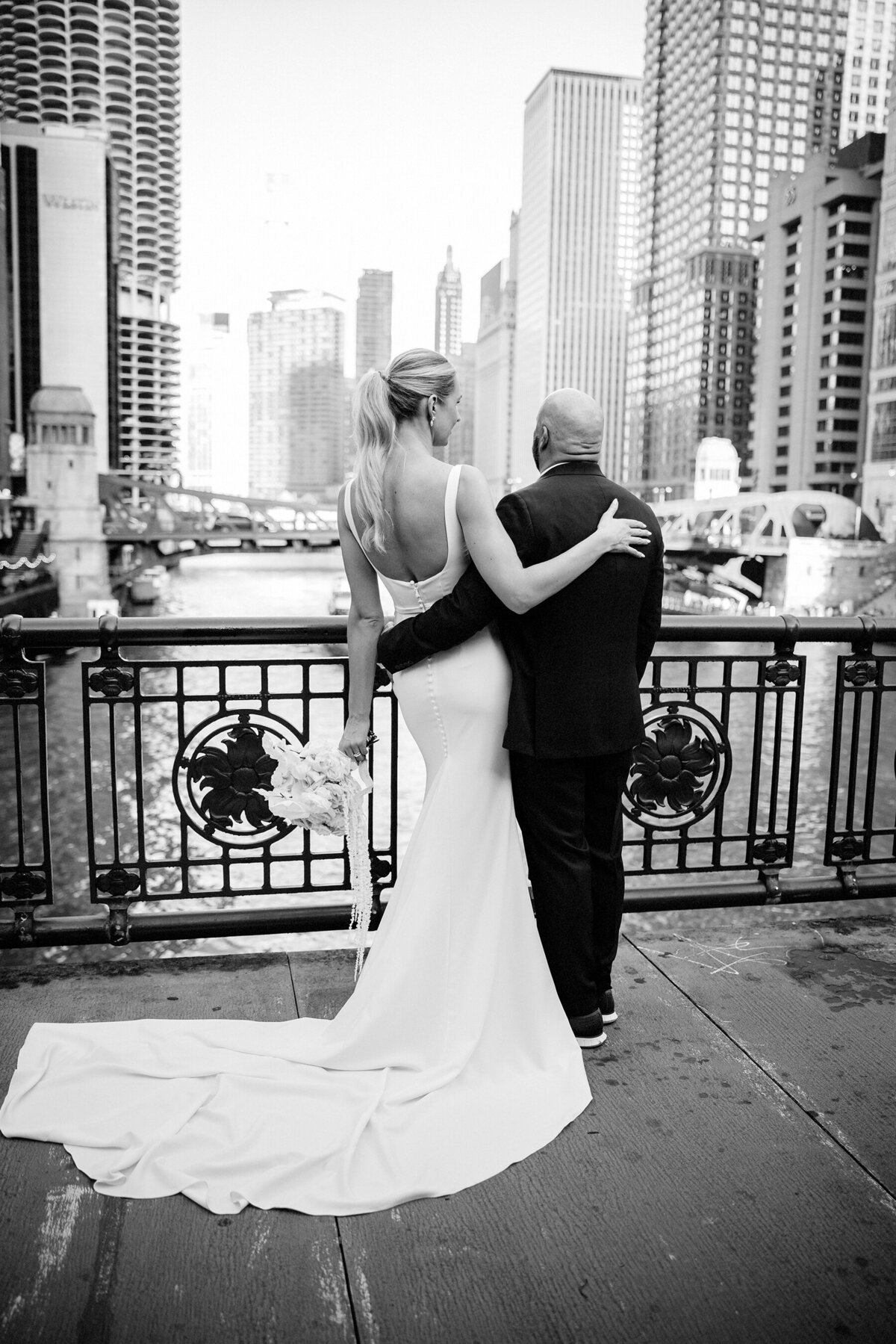 Black and white picture of short husband and tall wife  on the bridge in Chicago