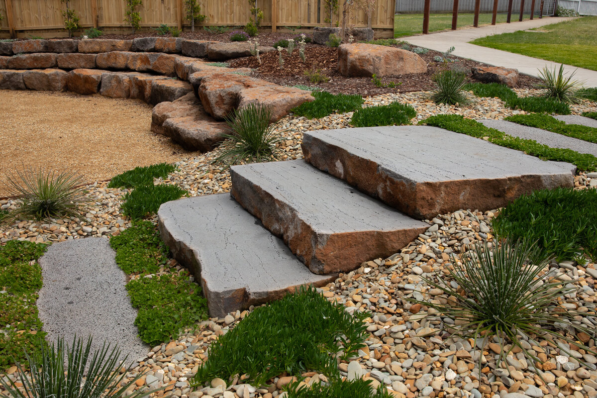 Natural Stone steps surrounded by rock wall in an elegant landscape design in Warrnambool. 
