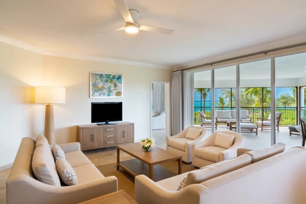 Sands-ocean-front-deluxe-one-bedroom-living-room-screened-in-wrap-around-balcony-two-sofa-sleeper-TV-coffee-table-0151-1024x683