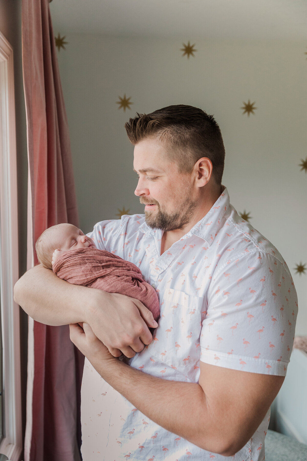 Dad Holds Newborn in Home Nursery