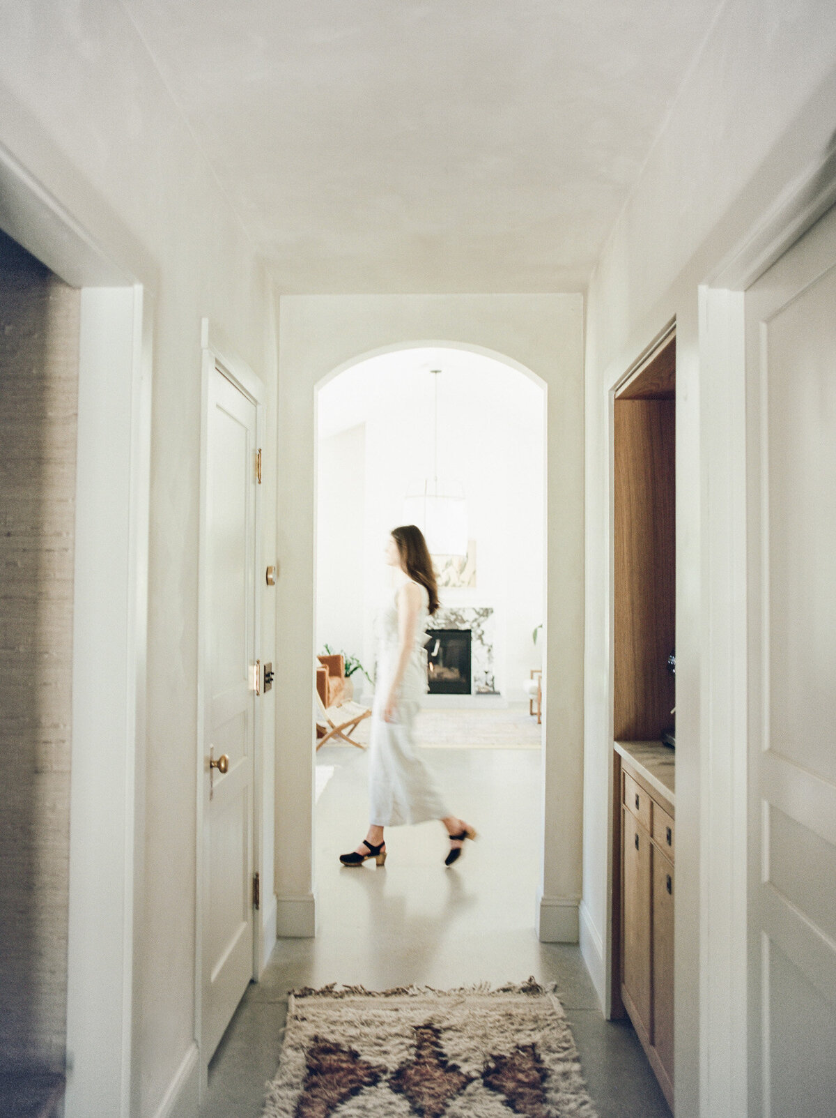 film branding photography for designer, movement brand photography of woman walking under arch at Fernhaus