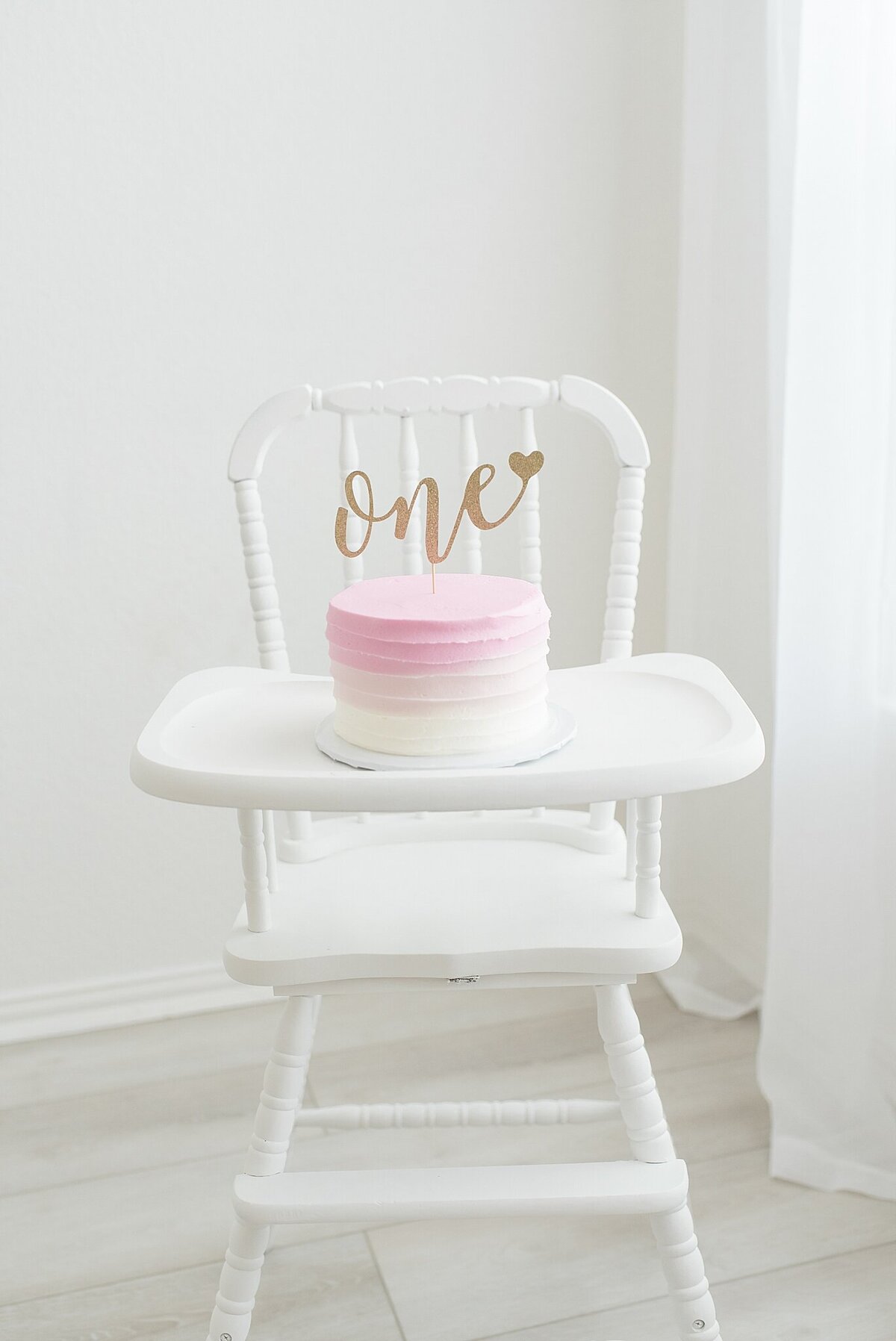 cake on vintage high chair with cake and one cake topper