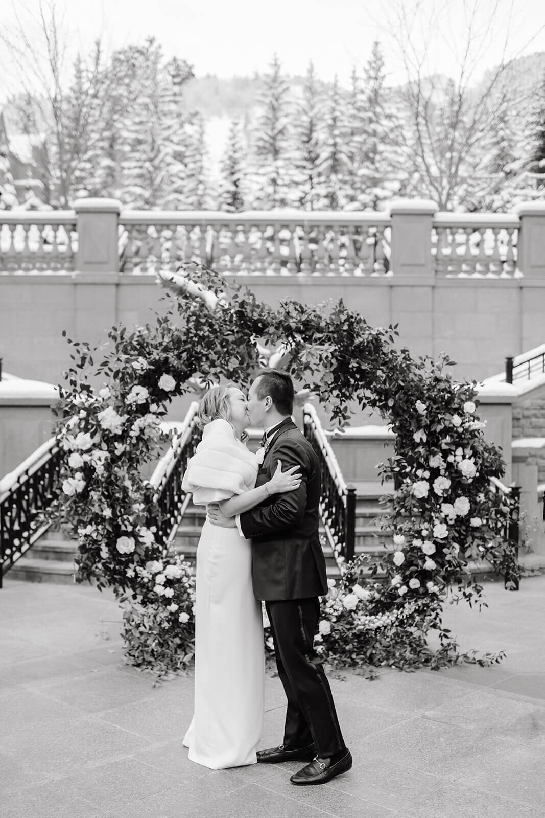 Bride and groom sharing a kiss after their ceremony at St. Regis Aspen, captured in a timeless black-and-white photograph.