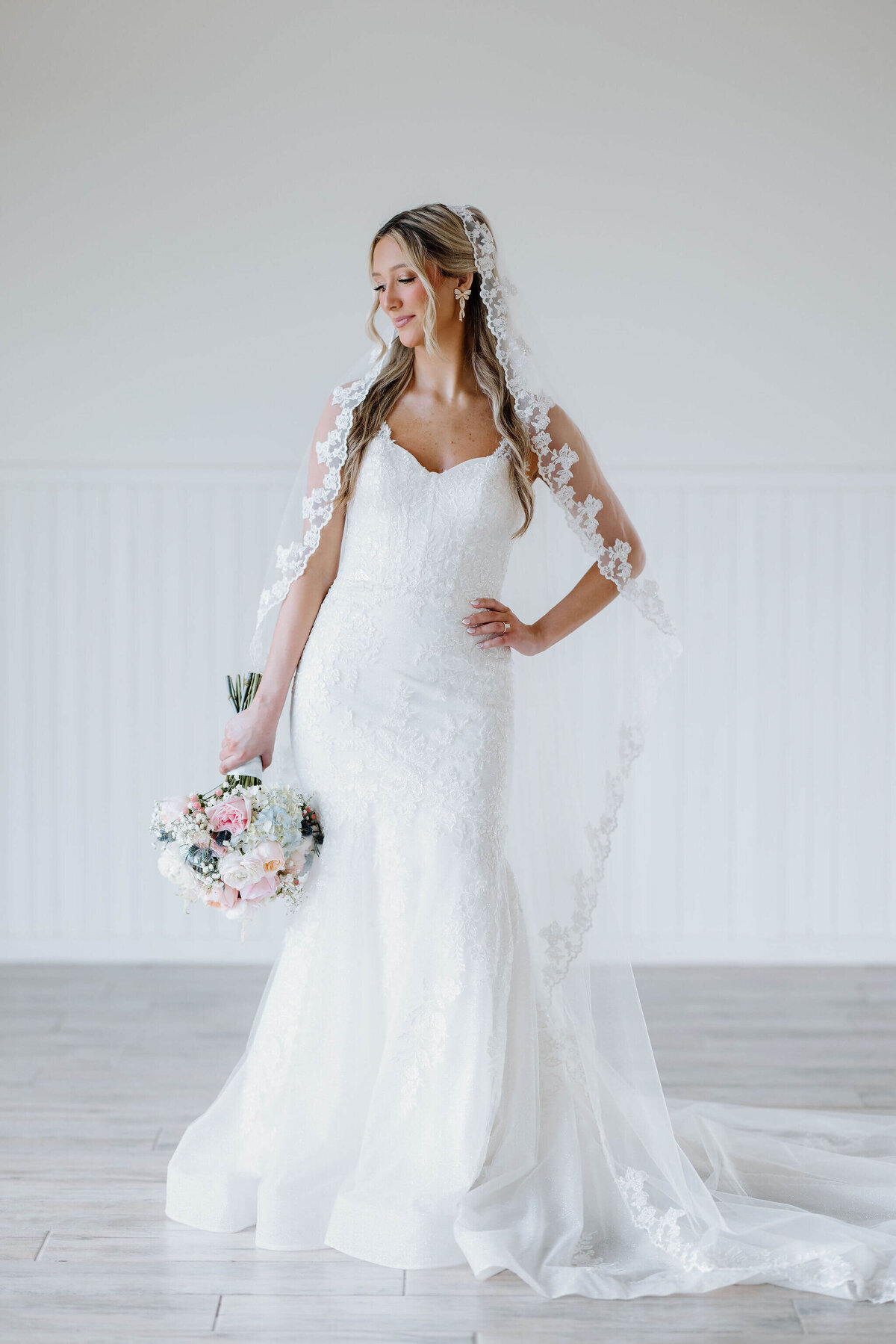 Bridal portraits in white lace wedding gown, cathedral length lace veil, and summer inspired bouquet