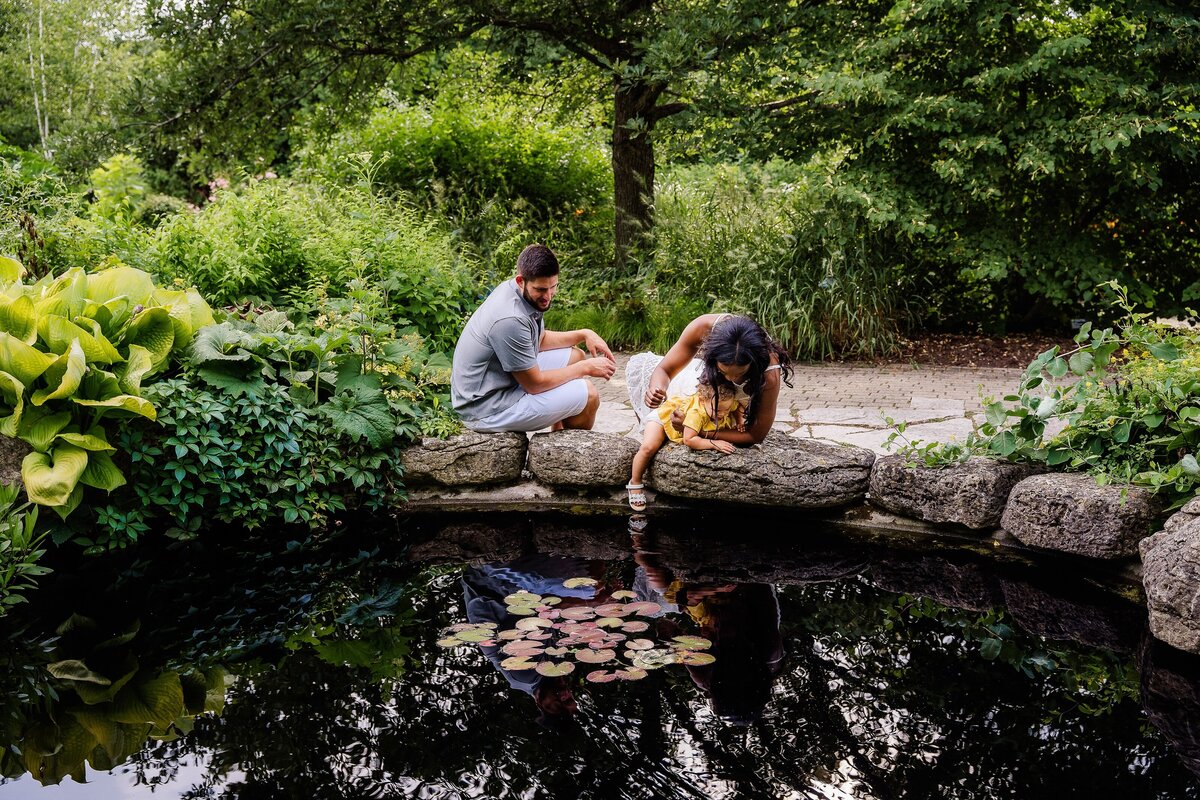 Family playing with toddler by the water