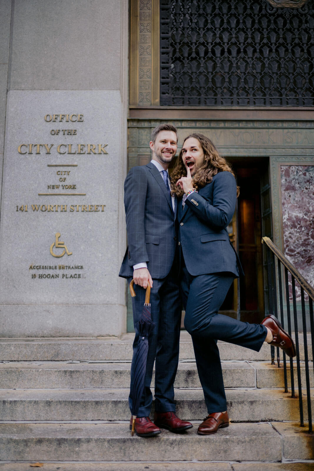 Wacky shot of the two grooms in front of the city clerk's office. NYC City Hall Elopement Image by Jenny Fu Studio