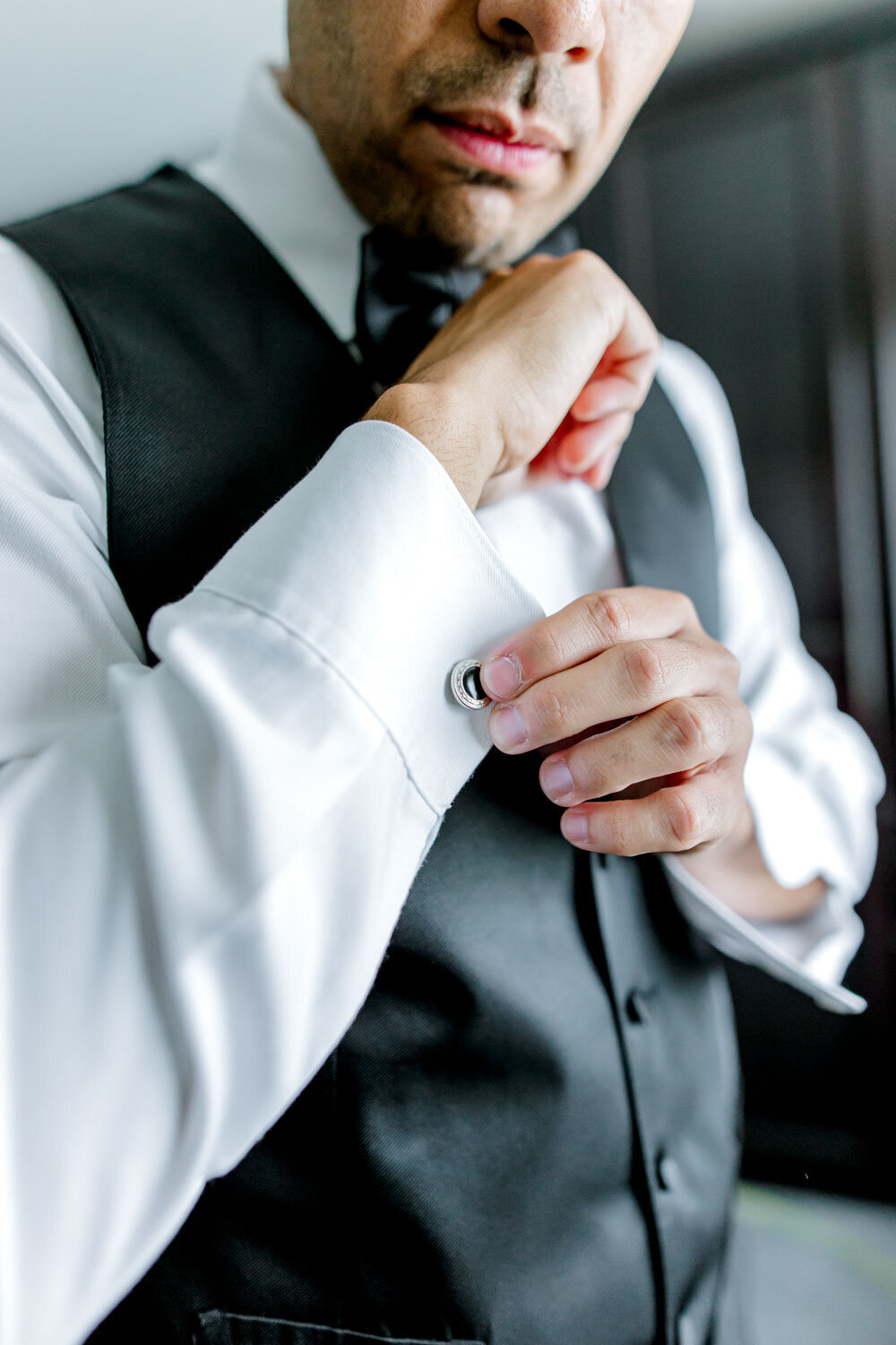 Groom adjusting cufflinks