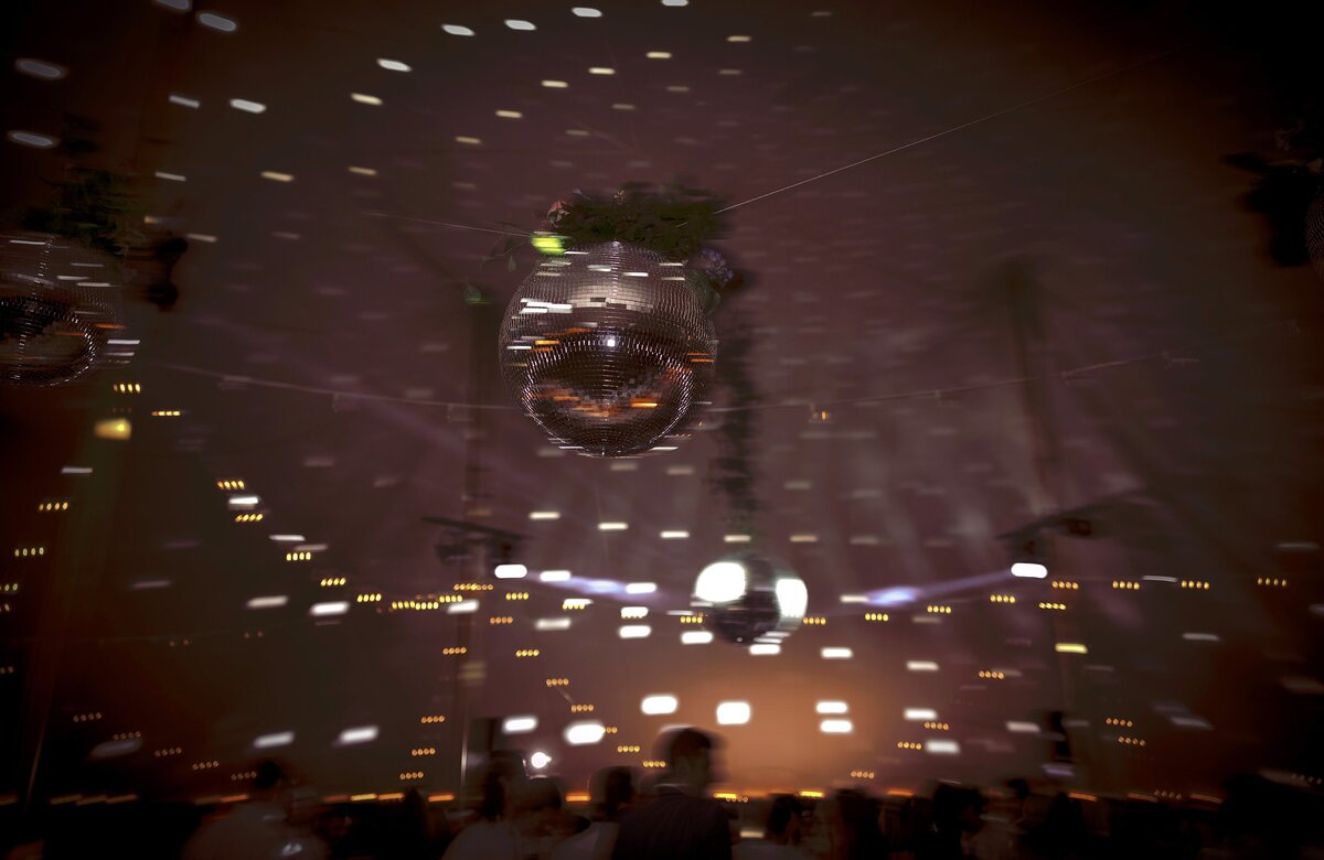 A disco ball spins during tented wedding reception.